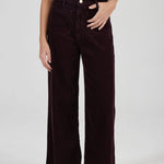 Person wearing dark brown wide-leg pants on a white background