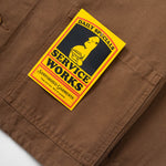 Brown pants with a 'Service Works' patch on a white background