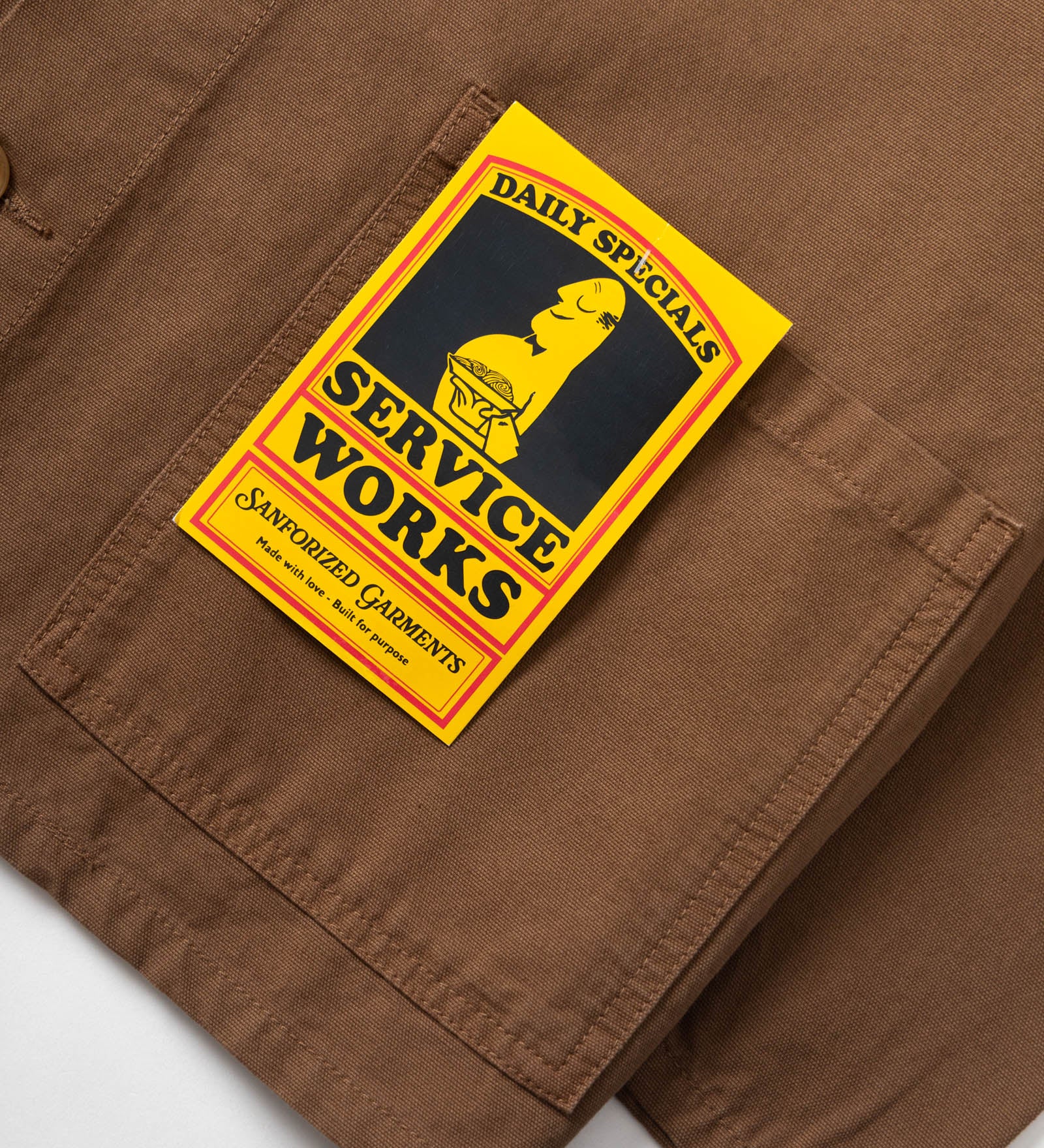 Brown pants with a 'Service Works' patch on a white background