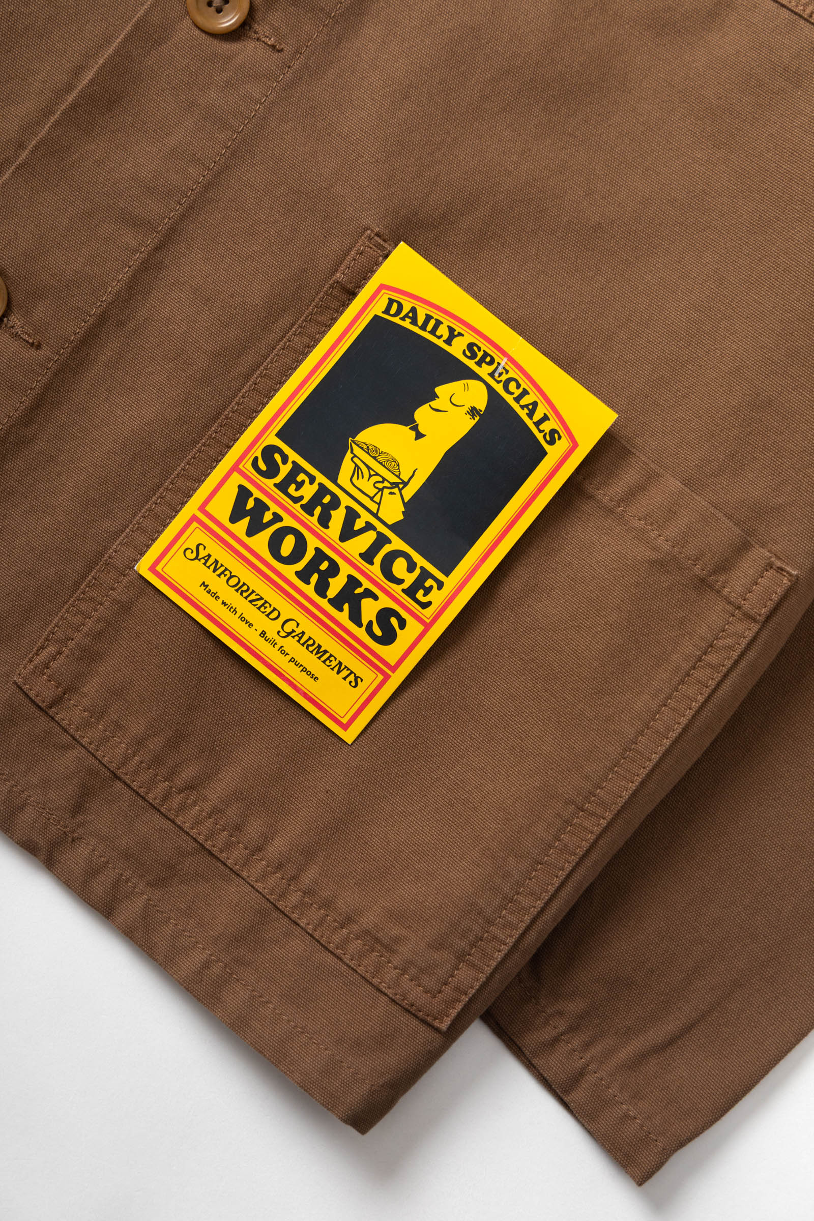 Brown pants with a 'Service Works' patch on a white background