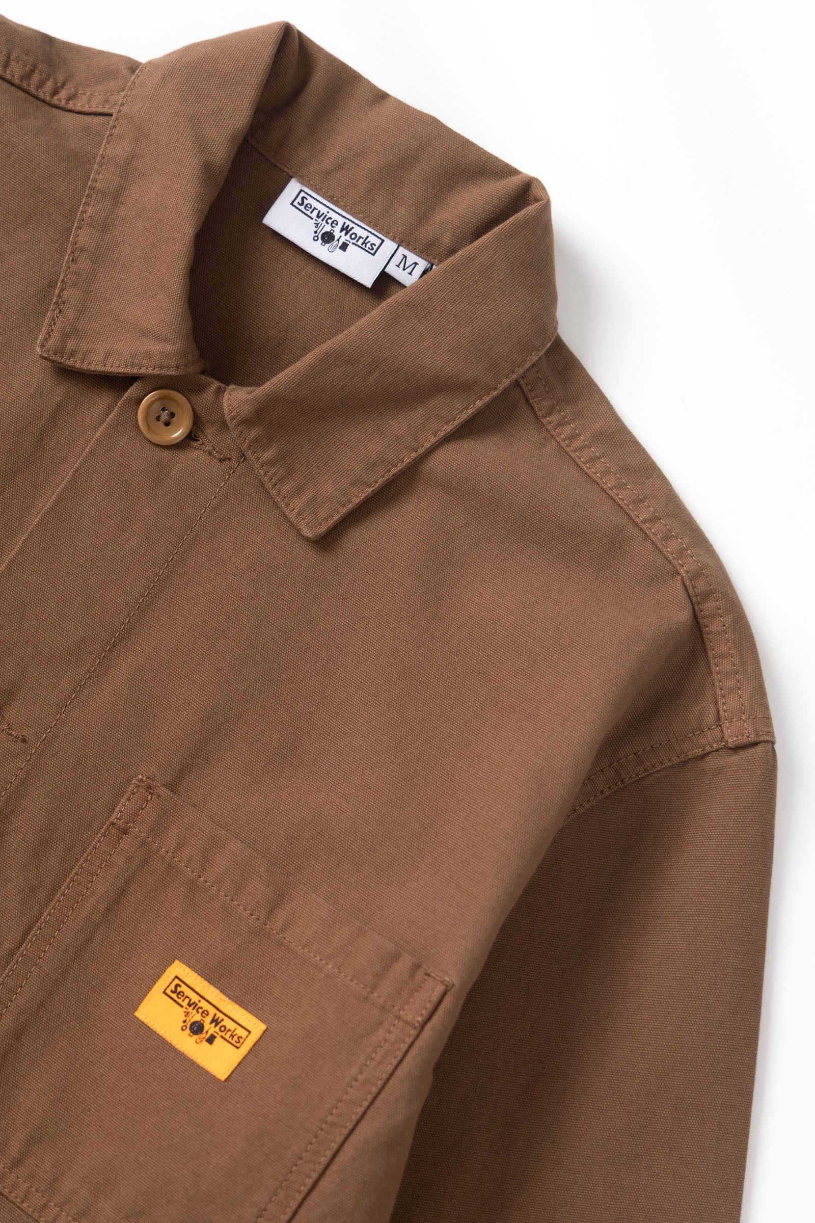 Brown jacket with visible brand labels on a white background