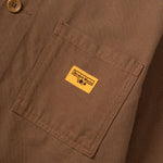 Close-up of a brown jacket with a yellow label on a matching brown background