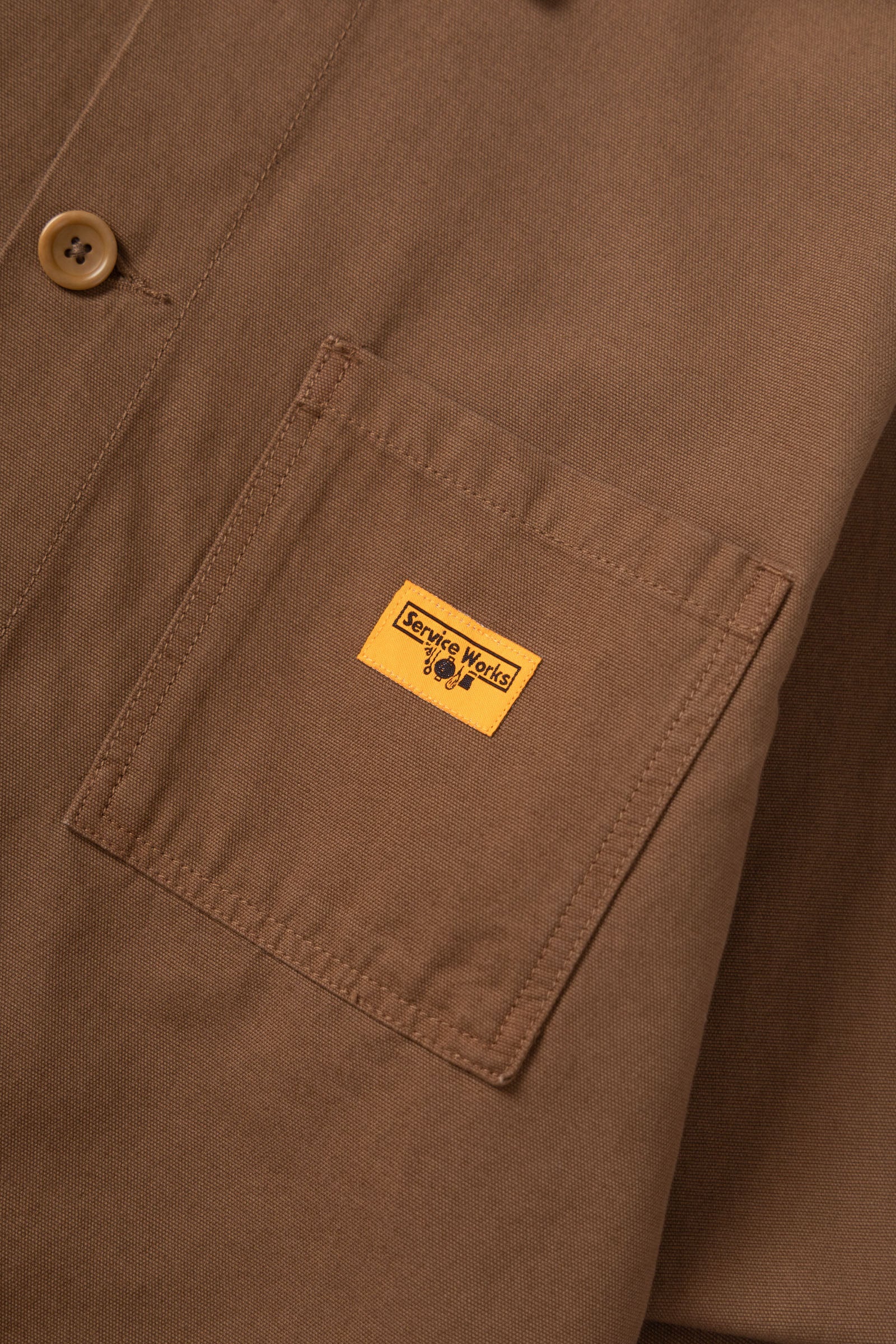 Close-up of a brown jacket with a yellow label on a matching brown background