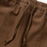Close-up of brown pants with drawstring on a white background