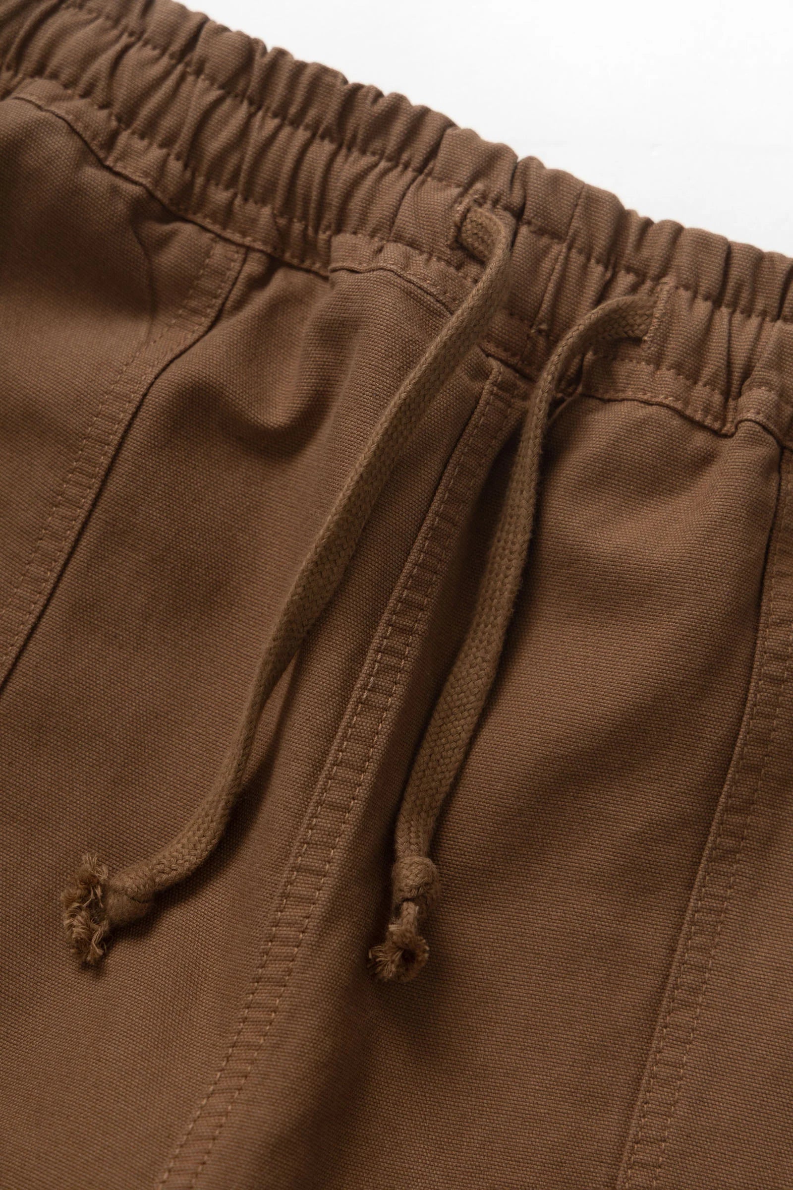 Close-up of brown pants with drawstring on a white background
