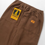 Brown pants with a visible brand label on a white background
