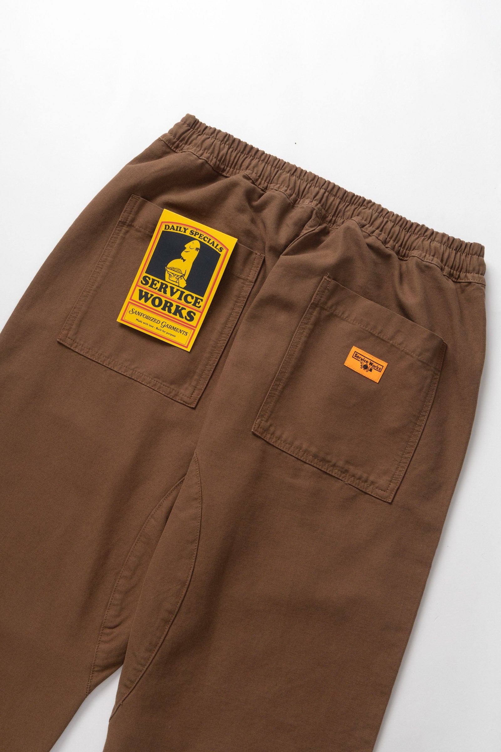Brown pants with a visible brand label on a white background