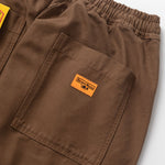 Brown pants with a logo patch on a white background