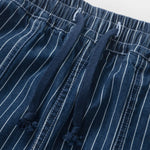 Close-up of blue pinstripe pants with a white background