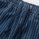 Close-up of blue pinstripe pants with a white background