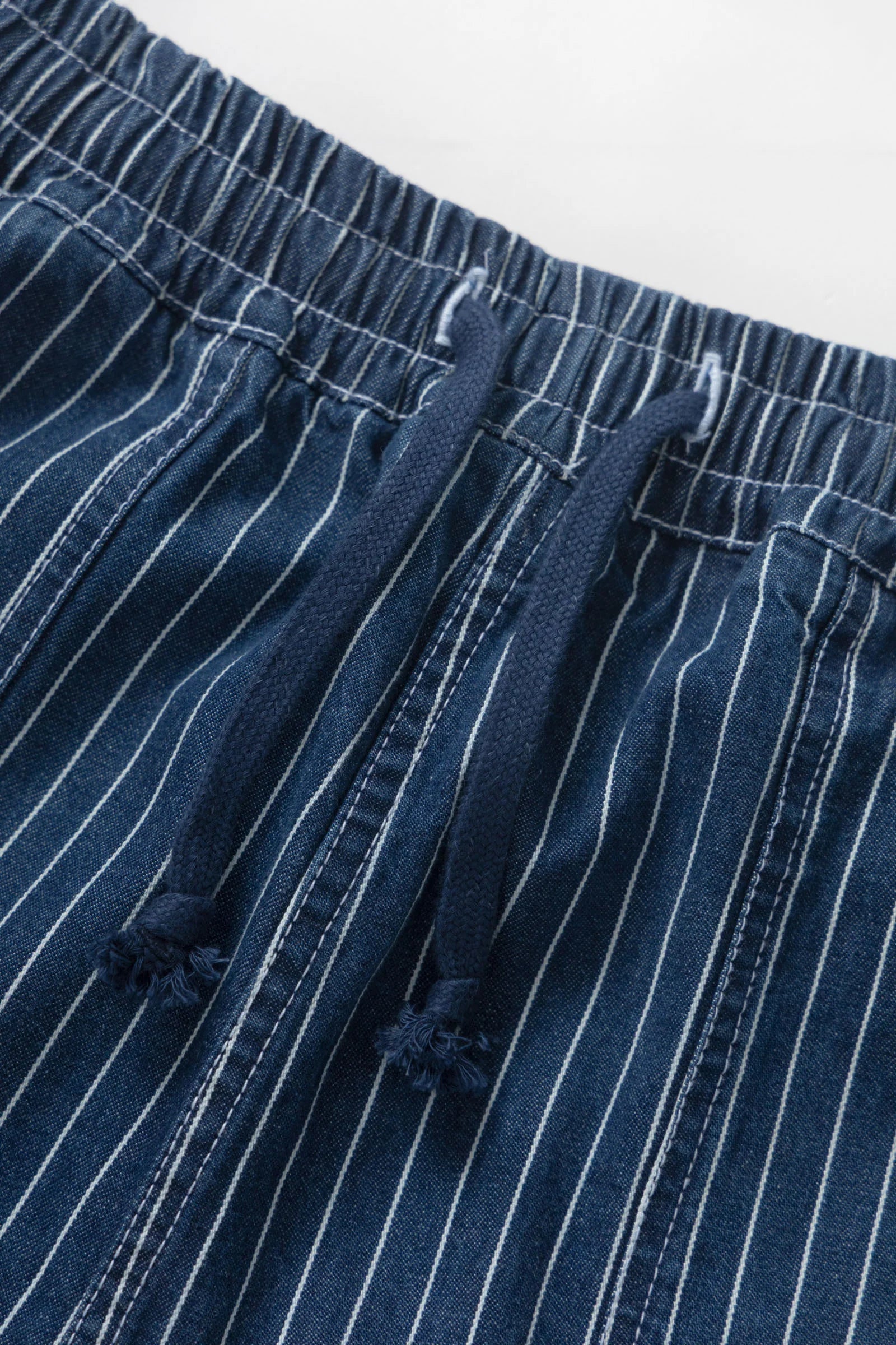 Close-up of blue pinstripe pants with a white background