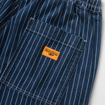 Close-up of blue pinstripe pants with an orange label on a white background