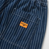 Close-up of blue pinstripe pants with an orange label on a white background