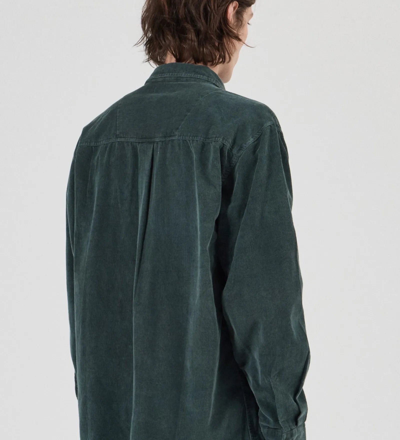 Person wearing a green shirt from behind on a white background