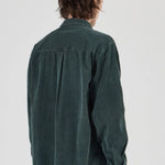 Person wearing a green shirt from behind on a white background