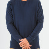 Person wearing a navy blue long-sleeve shirt on a white background