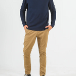 Person wearing a navy sweater and beige pants on a white background