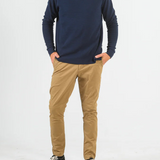 Person wearing a navy sweater and beige pants on a white background