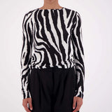 Person wearing a black and white zebra pattern sweater on a white background