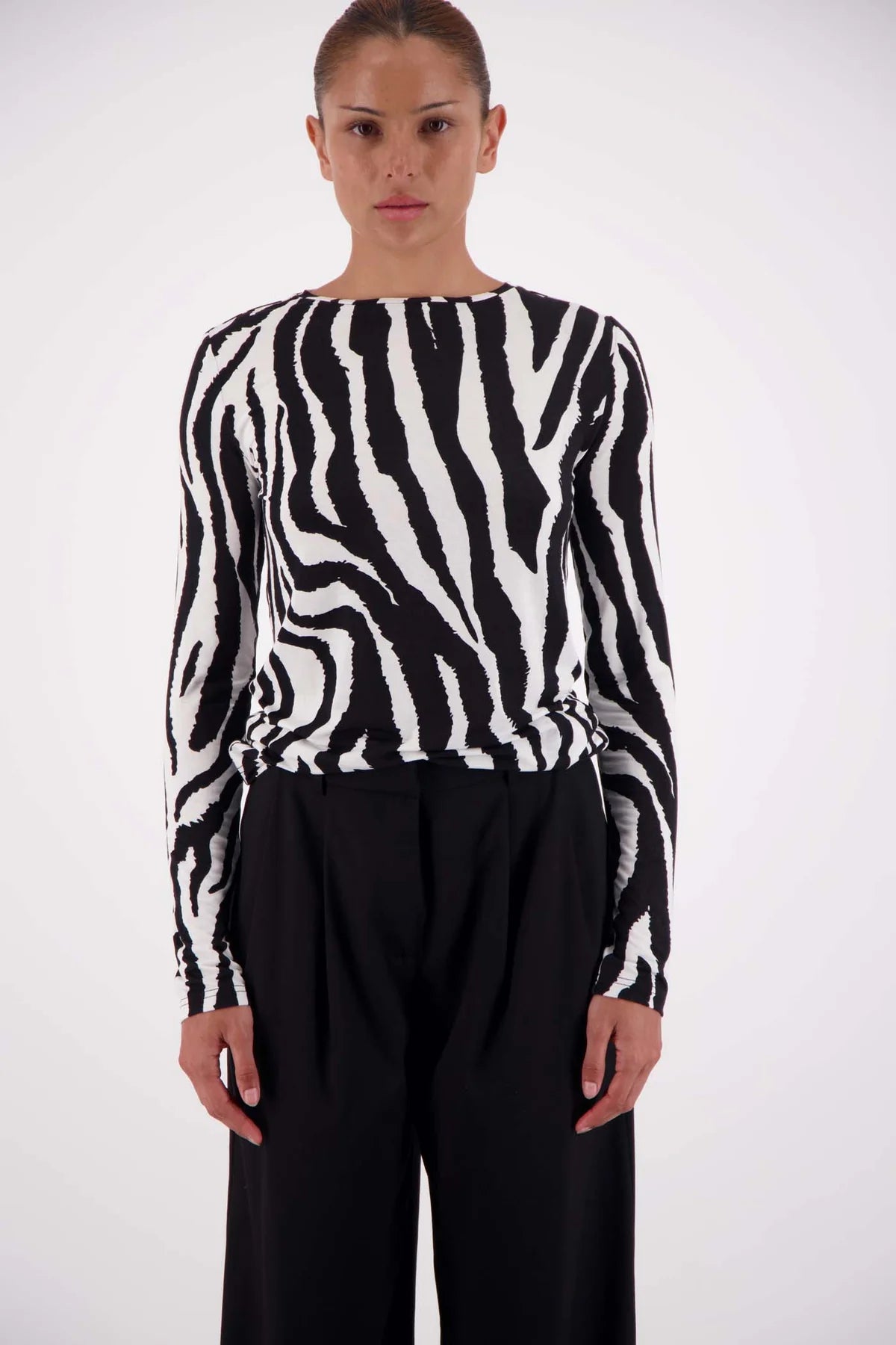 Person wearing a black and white zebra pattern sweater on a white background