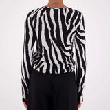 Person wearing a black and white zebra-striped sweater against a white background
