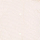 Close-up of a person wearing a light-colored shirt with a plain background
