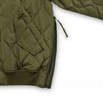 Green quilted jacket with a zipper on a white background