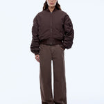 Person wearing a brown jacket and pants with a cap on a white background