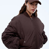 Woman wearing a brown jacket and cap with 'EP' logo on a white background