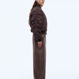 Person wearing a brown outfit with a cap on a white background