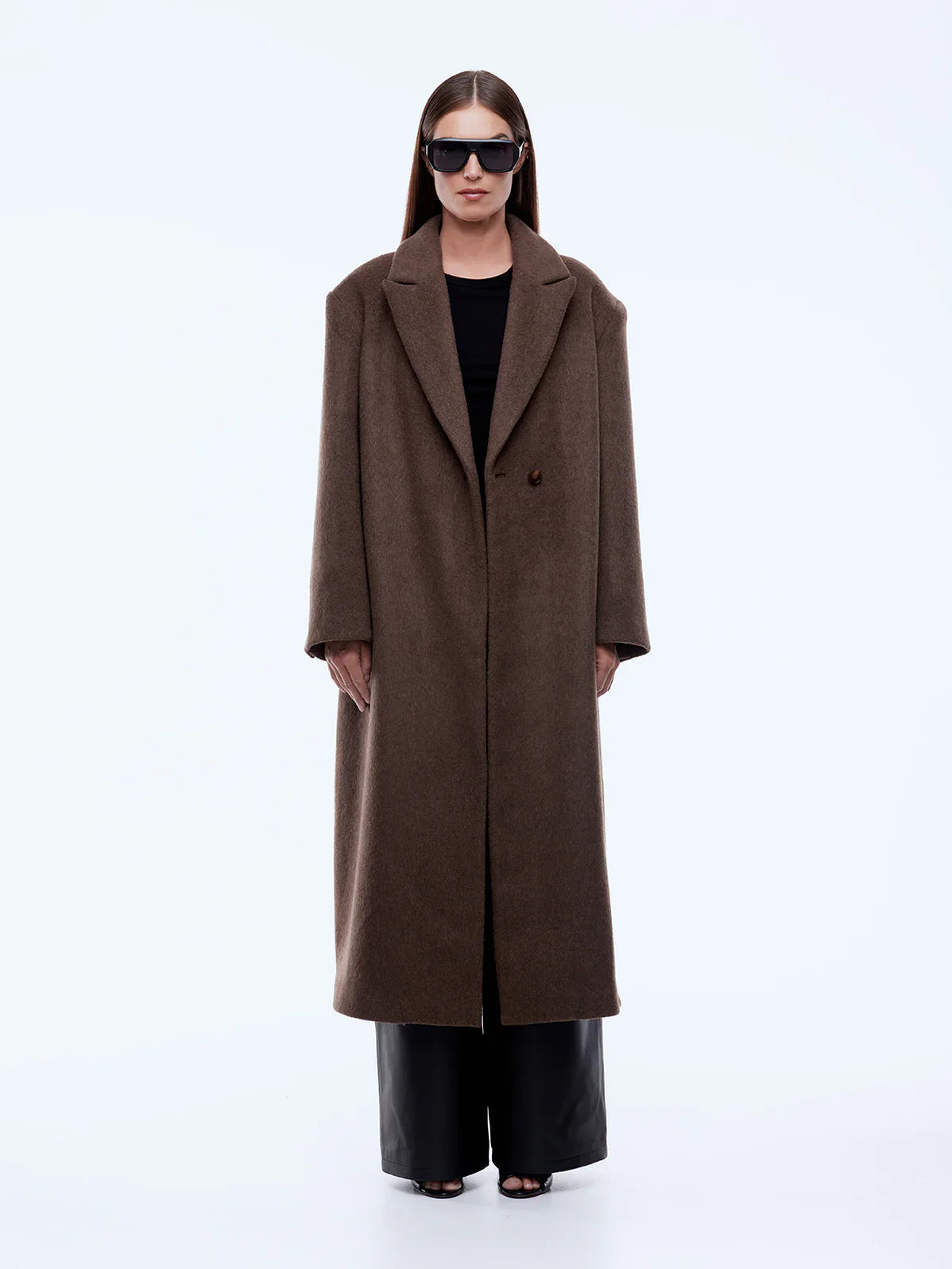 Person wearing a brown coat on a white background