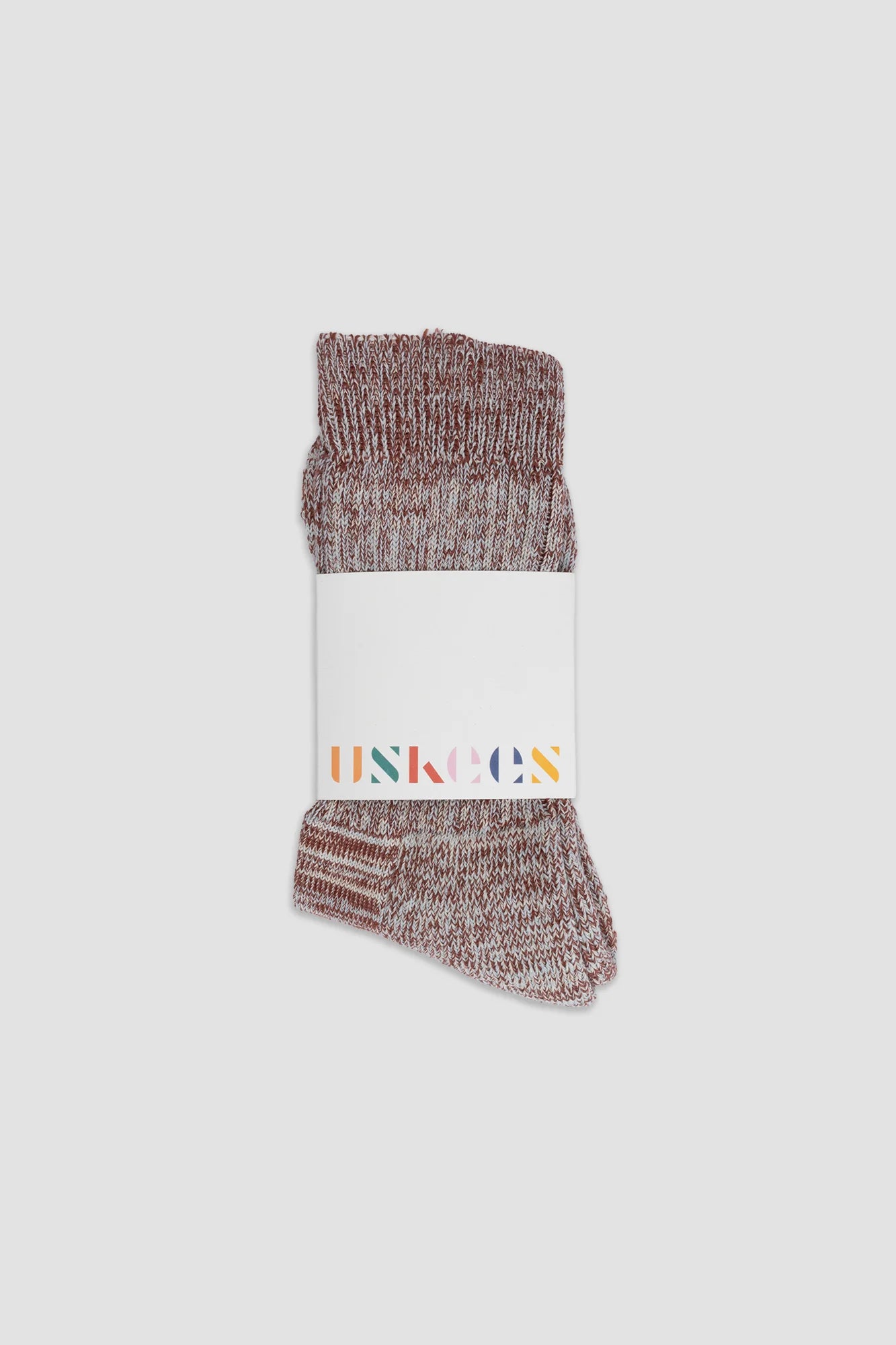 Pair of maroon socks with a white label on a light gray background
