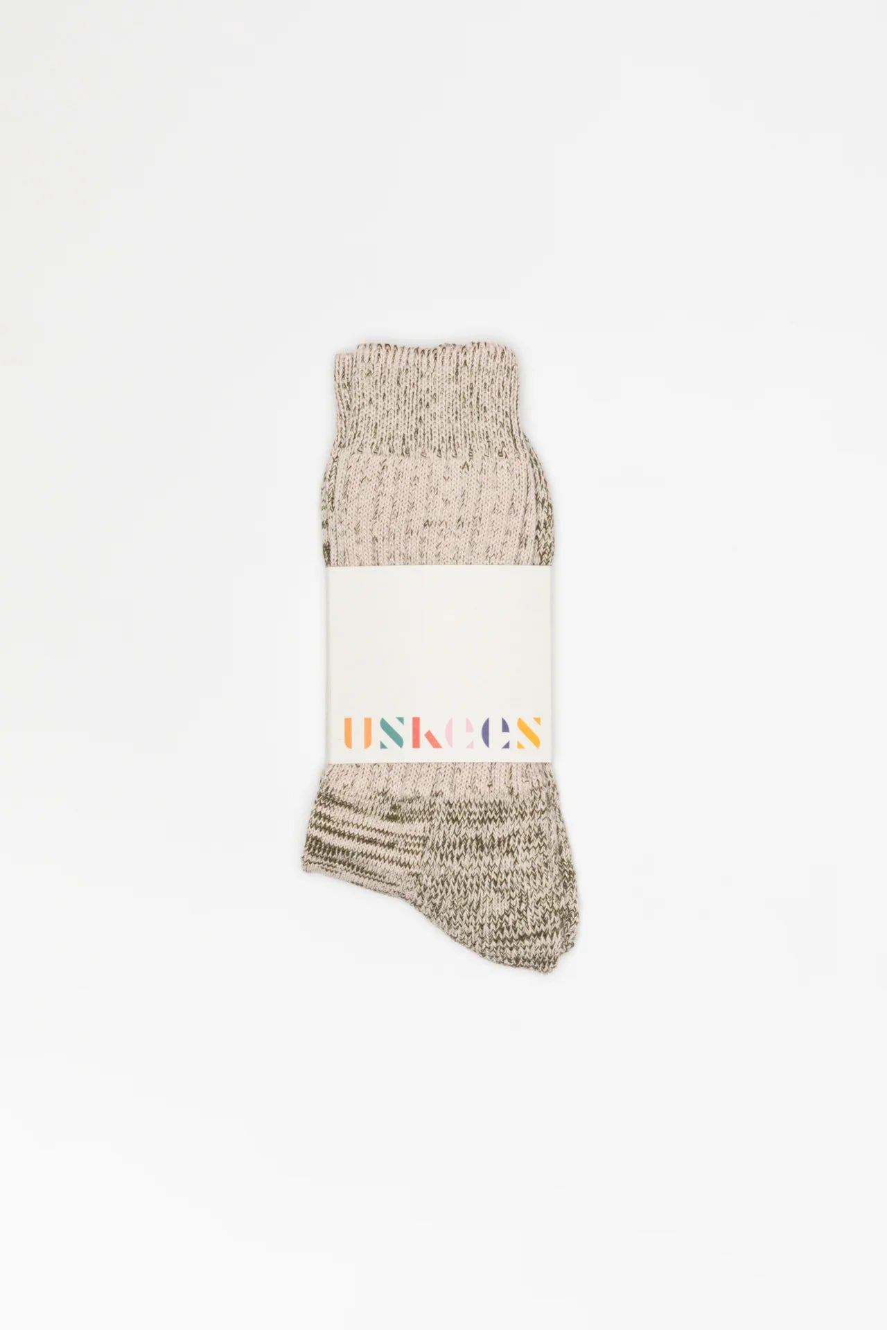 Beige textured sock with a white label on a white background