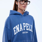 Person wearing a blue hoodie with 'ENAPELLY' branding on a white background