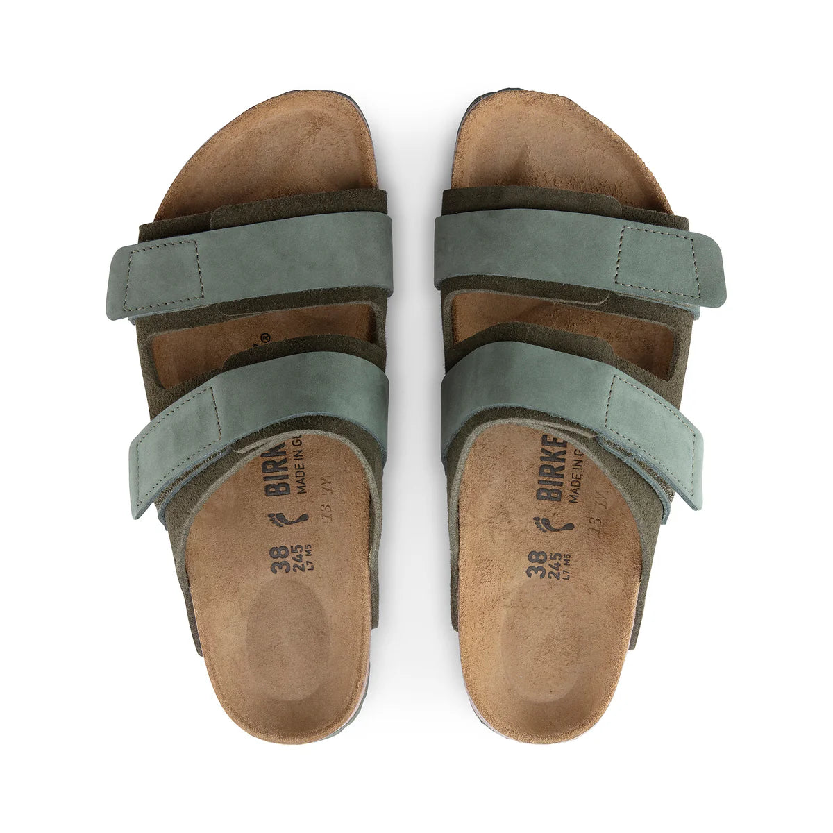 Pair of brown sandals with green straps on a white background