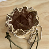 leather bag on a wooden table with a drawstring and chain