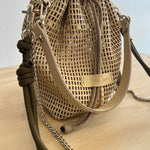 Woven handbag with chain detail on a neutral background