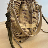Woven handbag with chain detail on a neutral background