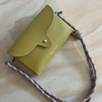 Mustard leather cross body bag in a wooden surface