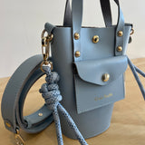 Light blue leather handbag with gold accents on a neutral background