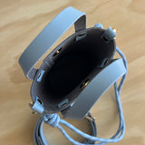 Blue leather bag on a wooden table.