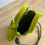 Lime green handbag with a strap on a wooden surface