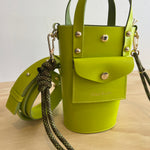Green handbag with a strap on a wooden surface
