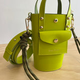 Green handbag with a strap on a wooden surface