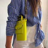 Person wearing a blue striped shirt with a yellow belt and white top underneath.