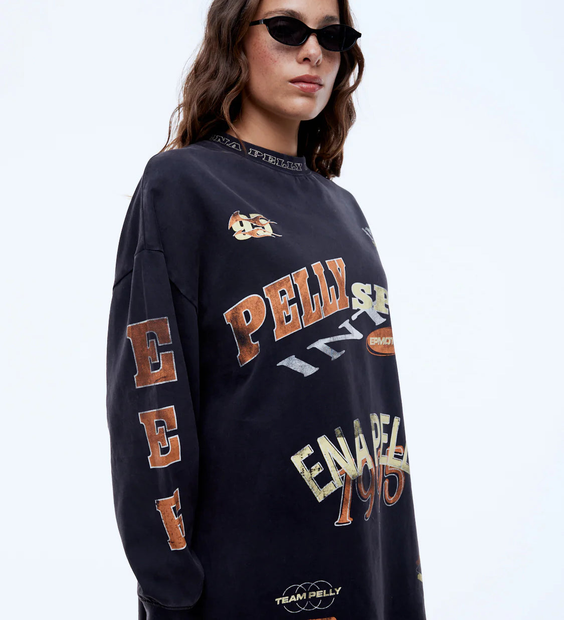 Person wearing a navy blue sweatshirt with multiple brand logos on a white background