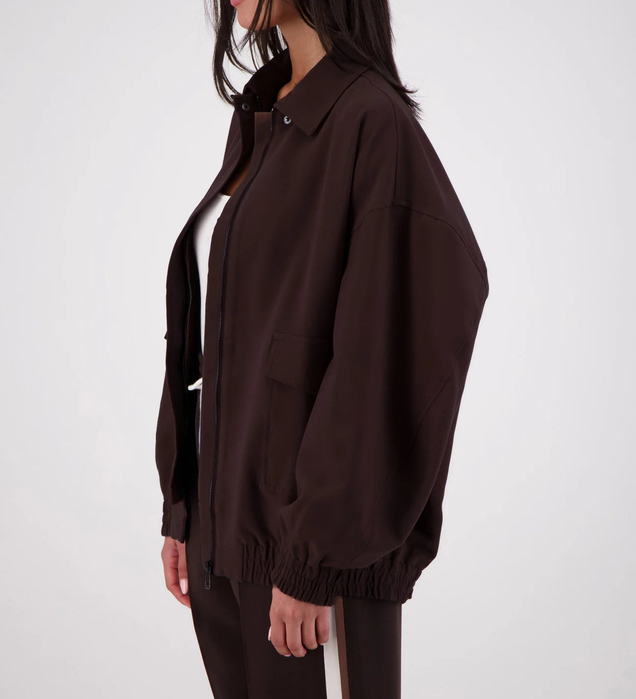 Person wearing a brown jacket and pants on a white background