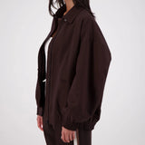 Person wearing a brown jacket and pants on a white background