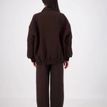 Person wearing a brown outfit on a white background