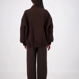 Person wearing a brown outfit on a white background